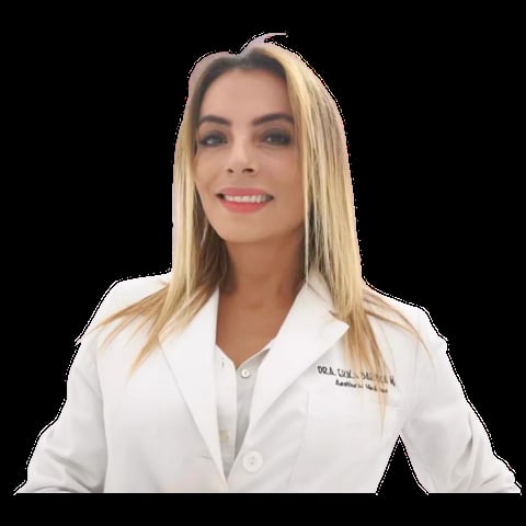 Professional woman with blonde hair wearing a white medical coat, smiling against a dark background