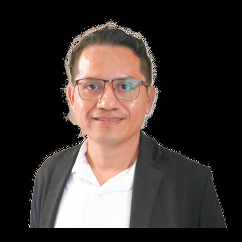 Professional headshot of a man wearing glasses, dark blazer, and white dress shirt against a black background