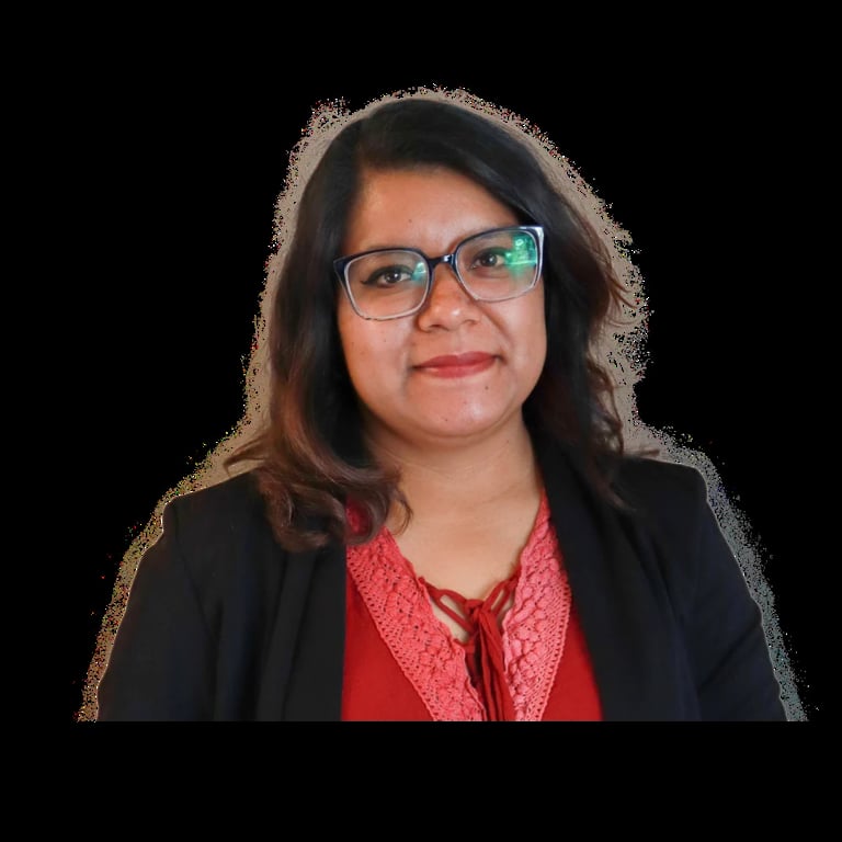 Professional headshot of a woman with dark shoulder-length hair, wearing glasses, red patterned blouse, and black blazer against a black background