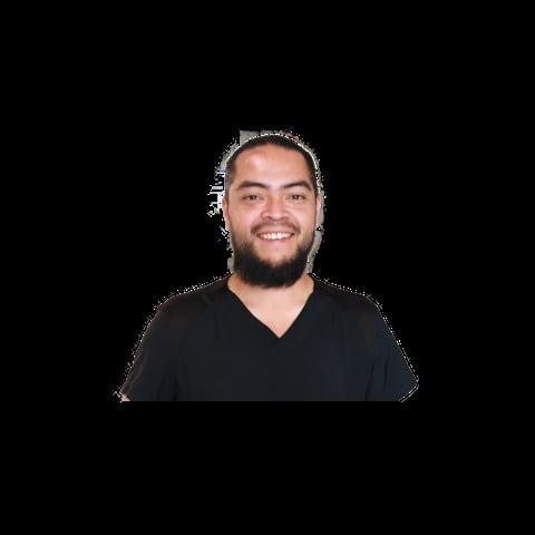 Portrait of a smiling man with a beard wearing a black v-neck shirt against a black background