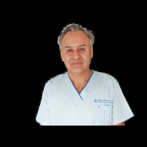 Middle-aged man with gray hair wearing light blue medical scrubs with embroidered text, photographed against a black background