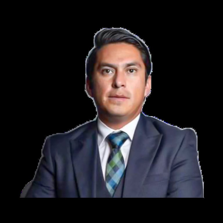 Professional headshot of a man in a dark navy suit and plaid tie against a black background