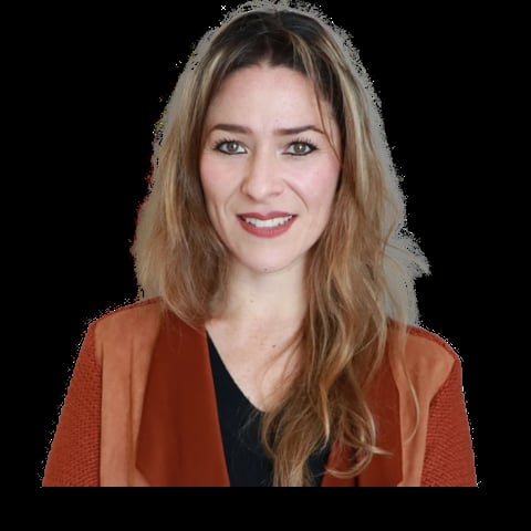 Woman with shoulder-length brown hair wearing a rust-colored cardigan over a black top, smiling at the camera against a black background
