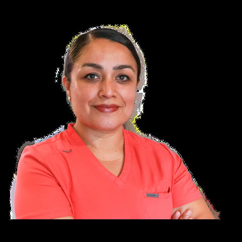 Professional headshot of a woman wearing a coral red v-neck t-shirt with arms crossed, smiling at the camera against a black background.