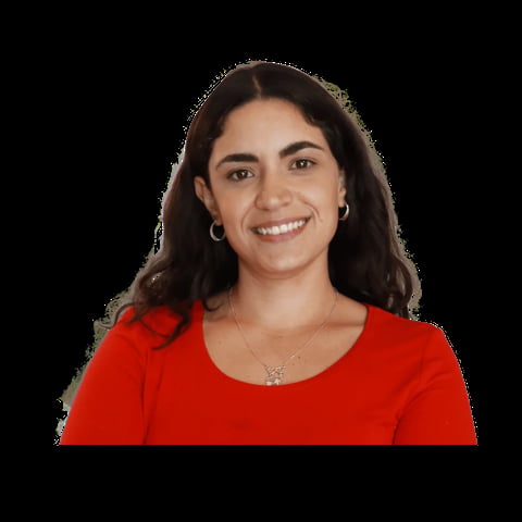 Portrait of a smiling woman with long dark hair wearing a red shirt against a black background
