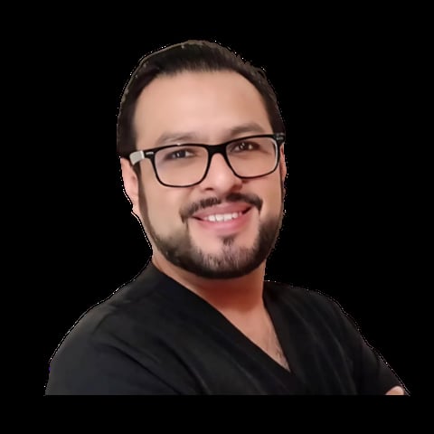 Portrait of a man wearing glasses and a black shirt, smiling at the camera against a black background