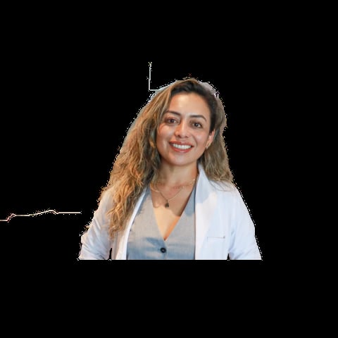 Professional headshot of a smiling woman with long wavy auburn hair wearing a white blazer over a gray top against a black background